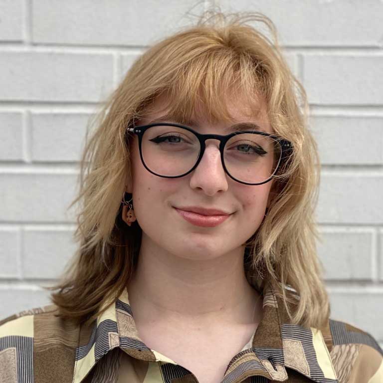 Smiling woman wearing flannel shirt. 